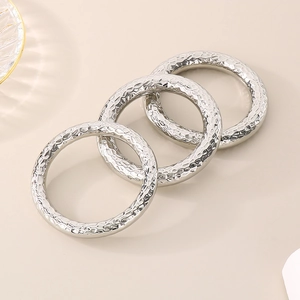 Close-up of three stacked silver stainless steel rings with hammer textured finish