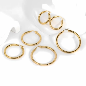 Detailed view of three pairs of graduated sizes 18k gold hollow hoop earrings in gold