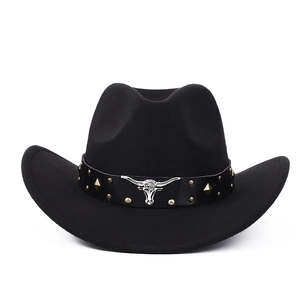 Detail of black felt cowboy hat featuring silver bull head ornament and metal studs