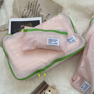 Detail view of pink mesh travel organizers with contrasting green zippers and yellow pulls
