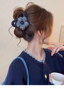 Détail de la pince à cheveux fleur tricotée bleu foncé avec perle élégante au centre