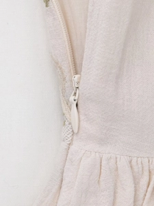 Close-up of invisible zipper and natural cotton linen texture on white dress