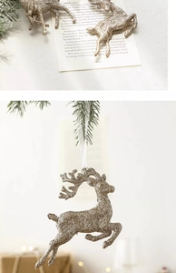 Macro detail of champagne gold glitter reindeer ornament hanging on a lush green pine branch