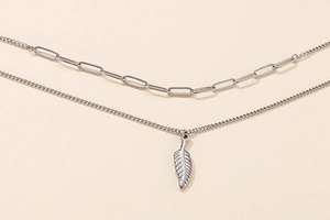 Detail of silver double-layered necklace with feather pendant and paperclip chain links