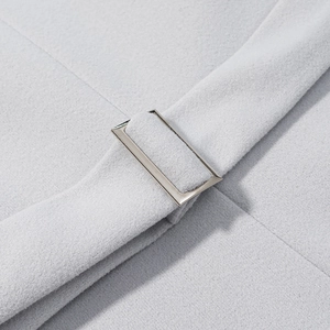 Dettaglio macro del cappotto di lana grigio chiaro con fibbia rettangolare in metallo argento