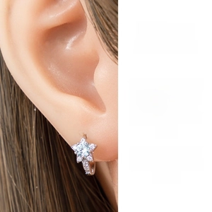 Close-up of star-shaped hoop earring with light blue zircon and micro-paved stones