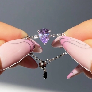 Détail d'une bague chaîne ajustable en argent avec pierre poire violette et breloque cœur