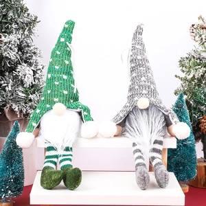 Gnomes de Noël avec bonnets tricotés vert et gris et longues barbes blanches sur décor de neige