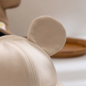 Detailed macro shot of cute 3D plush ears on a beige winter bucket hat for children