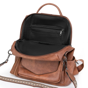 Vintage brown PU leather backpack with tassel detail and woven strap on white background