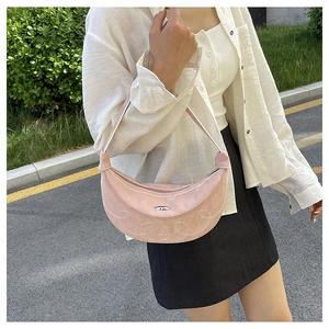 Borsa a mezzaluna rosa con cuciture bianche e fibbia in metallo indossata dal modello