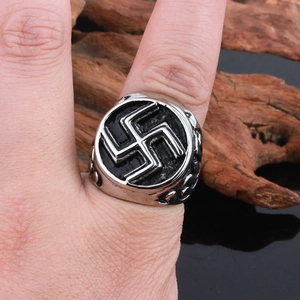 Vintage stainless steel cast ring for men featuring a traditional ethnic pattern on wood