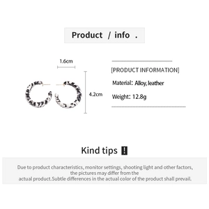 Detailed specs of C-shaped leopard print earrings featuring alloy and leather textures