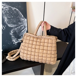 Detail of khaki quilted puffer tote bag showing soft cloud texture and handles