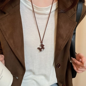 Detailed close-up of a brown horse pendant necklace with sparkling zircon accents