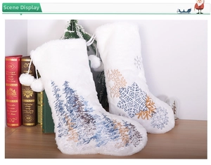Detail of plush Christmas stockings with embroidered snowflakes and blue forest patterns