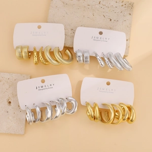 Detail of vintage gold and silver C-shaped hoop earrings set on jewelry cards