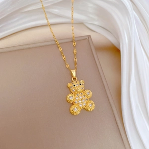 Detail shot of a teddy bear pendant necklace in gold with sparkling white zircon crystals