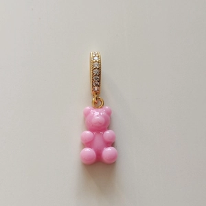 Close-up of pink translucent resin gummy bear pendant with gold crystal-inlaid ring