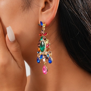 Detail of colorful crystal fringe earrings with floral design in vintage gold finish