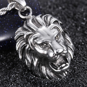 Detailed macro shot of a lion head pendant with intricate mane texture on black sand