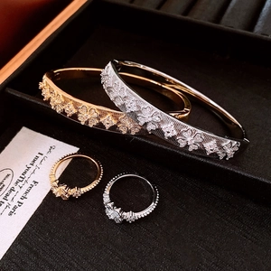 Détail de parure trèfle en or 18 carats et argent avec texture et zircons brillants