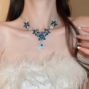 Detail of blue flower pendant necklace with cubic zirconia on a female model