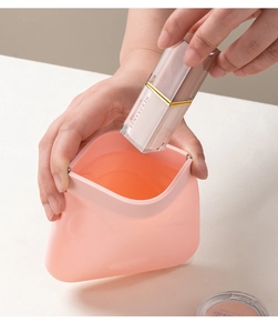 Pink silicone squeeze pouch for lipstick storage with soft flexible opening mechanism