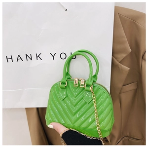 Detail of emerald jelly shell bag with chevron pattern and gold chain strap