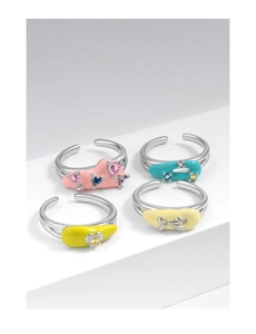 Set of four pastel enamel rings with zircon stones and various motifs on white stands