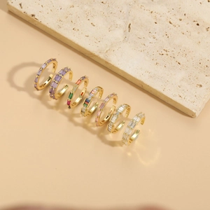 Detailed close-up of a 6-piece set of gold rings with colorful baguette-cut gemstones