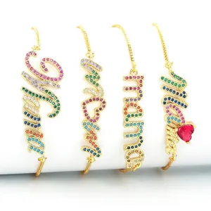Adjustable gold plated MAMA and SMILE bracelets with colorful zircon stones on white display