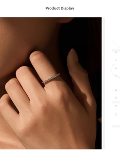Detailed view of a slim gold band ring featuring a row of delicate light blue diamonds