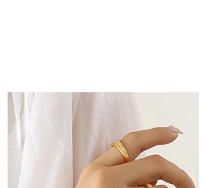 Primer plano de un anillo minimalista de oro con una circonita en la mano de una modelo