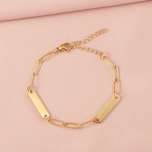 Detail of adjustable gold paperclip bracelet with engravable rectangular metal bars