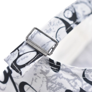 Close-up of adjustable cotton baseball cap strap with metal buckle and artistic lettering