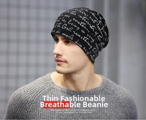 Close-up of black breathable beanie with white cursive text print worn by a male model
