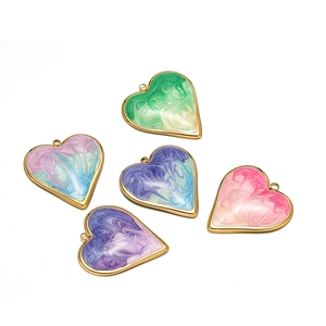 Flat lay of heart-shaped stainless steel pendants in five assorted gradient enamel colors