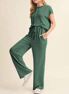 Detail of dark green ribbed knit texture on two-piece casual wide-leg pants set