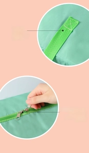 Detail view of reinforced wide green handles and durable metal zippers on oxford storage bag