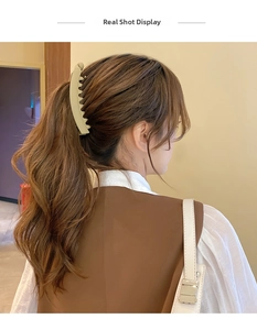 Light green matte banana hair clip holding a ponytail on brown wavy hair