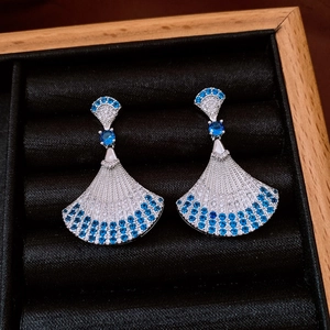 Detailed shot of fan-shaped earrings with blue and white zircon in a black jewelry box