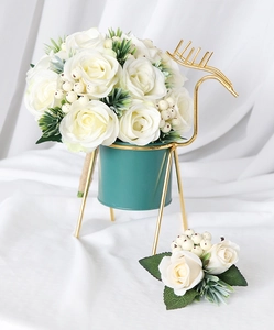 Detailed view of white rose boutonniere set with elegant gold deer stand and green pot