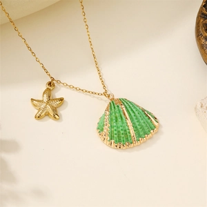Macro view of gold starfish and emerald green shell pendant on a thin necklace chain