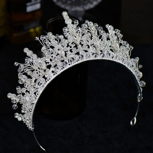 Elegant silver bridal crown with crystal flower and leaf designs on dark background