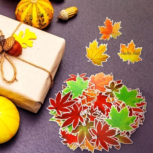 Close-up of colorful autumn maple leaf cutouts on table with festive fall decorations