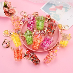 Creative fruit milk tea cup keychains with liquid and sequins in a pink gift setting