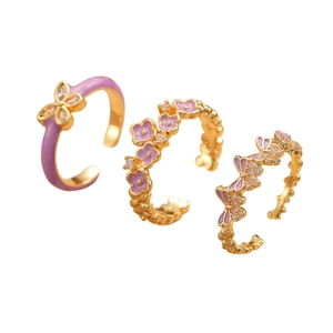 Detail of three 18K gold plated butterfly and flower rings with lavender enamel and zircon
