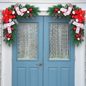 Christmas door corner garlands with red poinsettias and ornaments on white walls