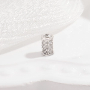 Macro detail of silver S925 sterling silver cylinder bead with triple rows of pavé zircons